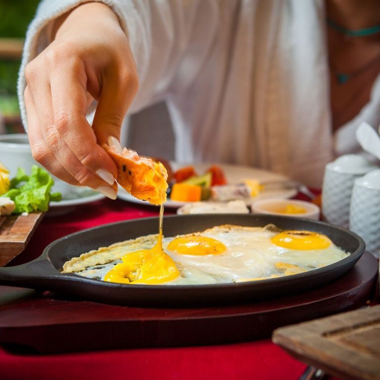 close-up-breakfast-table-with-red-tablecloth-fried-eggs-cheese-cheese-cucumbers-tomatoes-lettuce-coffee_176474-2432.jpg