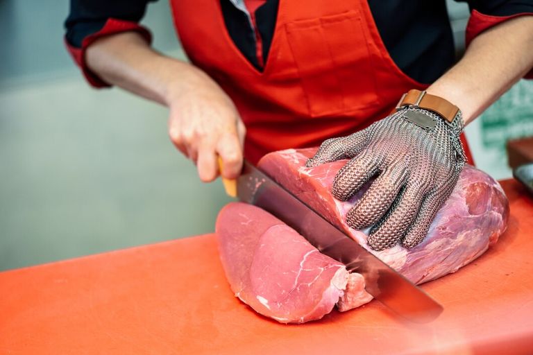 woman-cutting-fresh-meat-butcher-shop-with-metal-safety-mesh-glove_1139-1726.jpg
