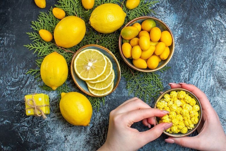 overhead-view-collection-cut-whole-natural-organic-fresh-citrus-fruits-fir-branches-hand-taking-one-candies-pot-dark-background_140725-131965.jpg