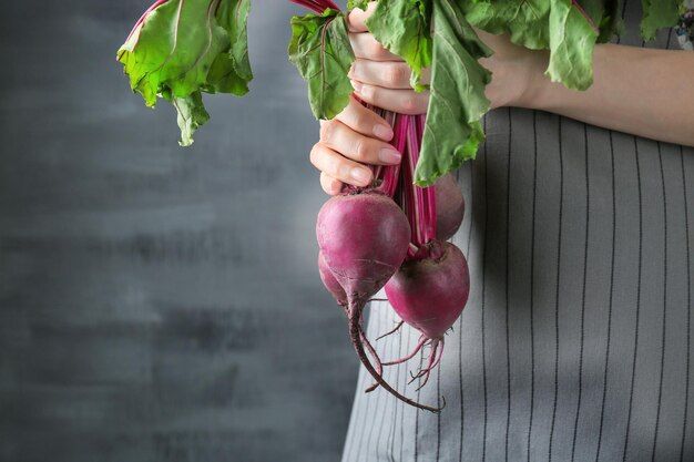 woman-holding-young-beets-grey-background_392895-474705.jpg