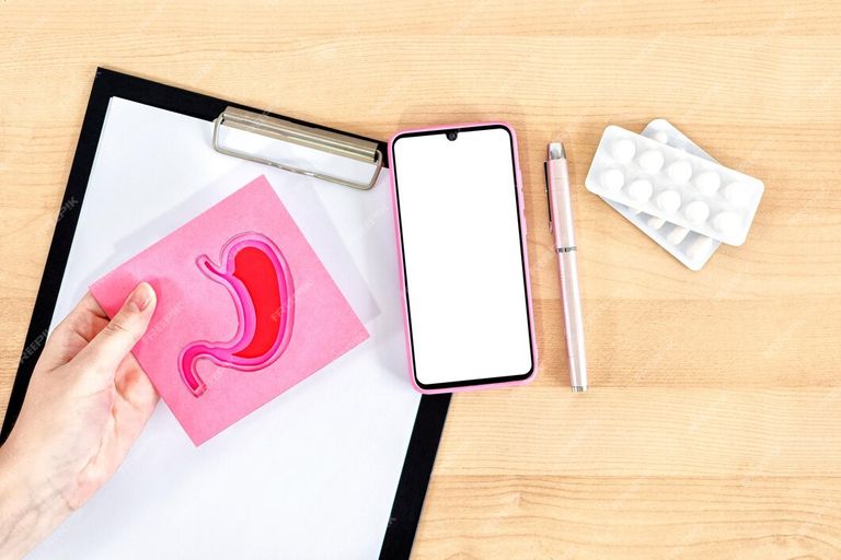 female-hands-holding-stomach-figure-smart-phone-clipboard-pills-wooden-desk_145713-5808 (1).jpg