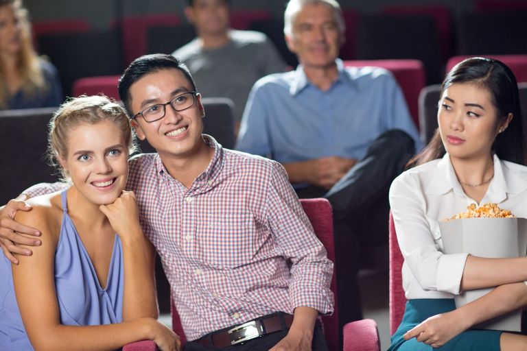 happy-couple-watching-movie-girl-looking-at-them.jpg
