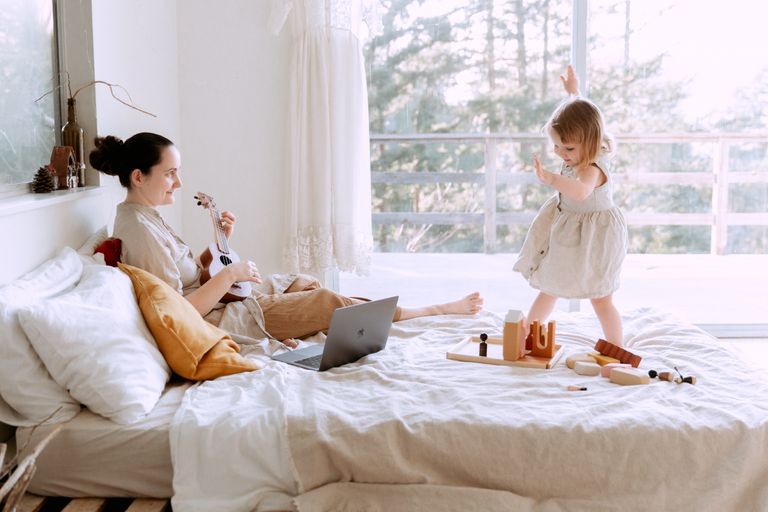 happy-young-woman-playing-ukulele-for-daughter-at-home-3975635.jpg