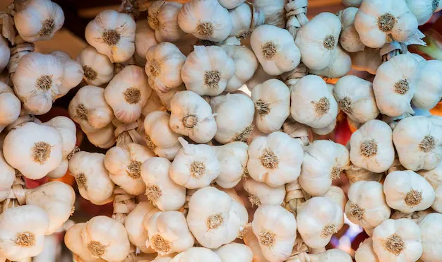 background-garlic-close-up-garlic-market-stand_1391-242 (1).webp