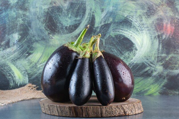 wooden-piece-natural-fresh-eggplants-stone-surface_114579-57041.jpg