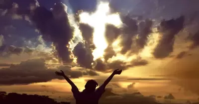 11628-cross-appearing-in-sunset-sky-woman-praising.webp