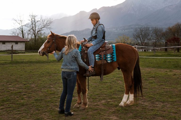 female-equestrian-instructor-teaching-child-how-ride-horse_23-2150460655.jpg