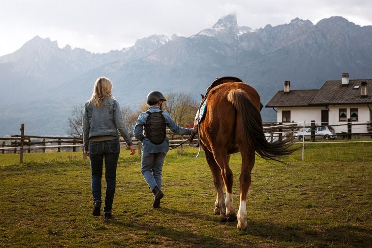 female-equestrian-instructor-teaching-child-how-ride-horse_23-2150460622.jpg