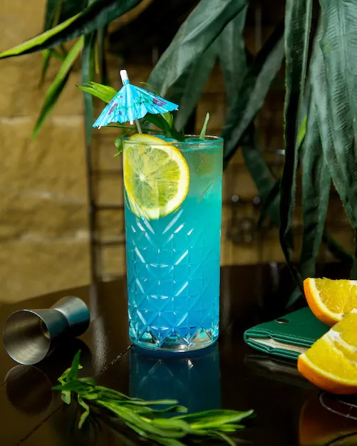 crystal-glass-blue-lagoon-garnished-with-lemon-slice-cocktail-umbrella_140725-8522.webp