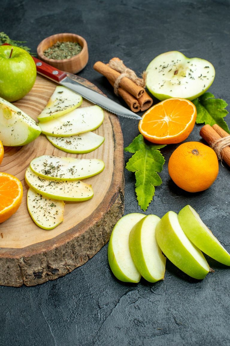 bottom-view-apple-tangerines-slices-knife-wood-board-cinnamon-sticks-tied-with-rope-dried-mint-powder-dark-backgrund_140725-146021.jpg