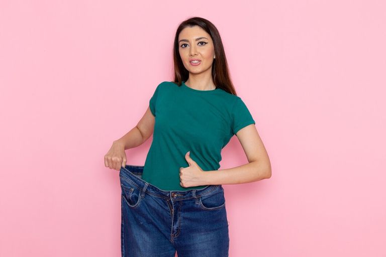 front-view-young-female-green-t-shirt-checking-her-waist-pink-wall-waist-sport-exercise-workouts-beauty-slim-athlete_140725-65179.jpg