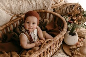 free-photo-of-a-baby-sitting-in-a-basket-with-autumnal-decorations.jpeg