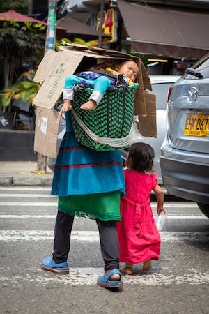 free-photo-of-baby-in-a-basket-on-the-back-of-his-mother-leading-her-daughter-by-the-hand.jpeg