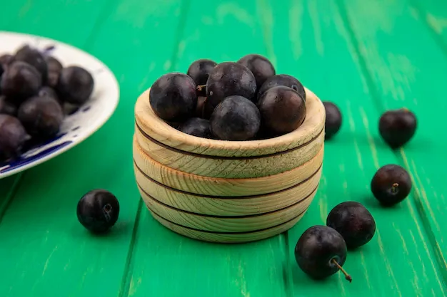 side-view-sloe-berries-bowl-plate-green-background_141793-27509.webp