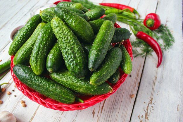 fresh-organic-cucumbers-red-basket-white-wooden-table-with-green-red-chili-peppers-fennel-salt-black-peppercorns-garlic-pea-close-up-healthy-concept-top-view-flat-lay_114579-1179.jpg