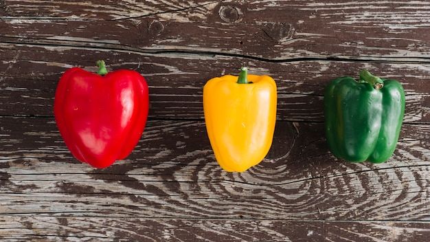 elevated-view-red-yellow-green-bell-peppers-damaged-wooden-surface_23-2148082676.jpg