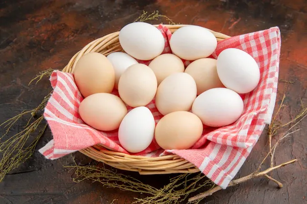 front-view-white-chicken-eggs-inside-basket-with-towel-dark-surface_140725-103361.webp