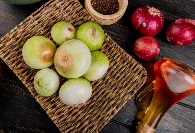 side-view-white-onions-basket-plate-with-red-ones-melted-butter-black-pepper-seeds-wooden-background_141793-9476.jpg