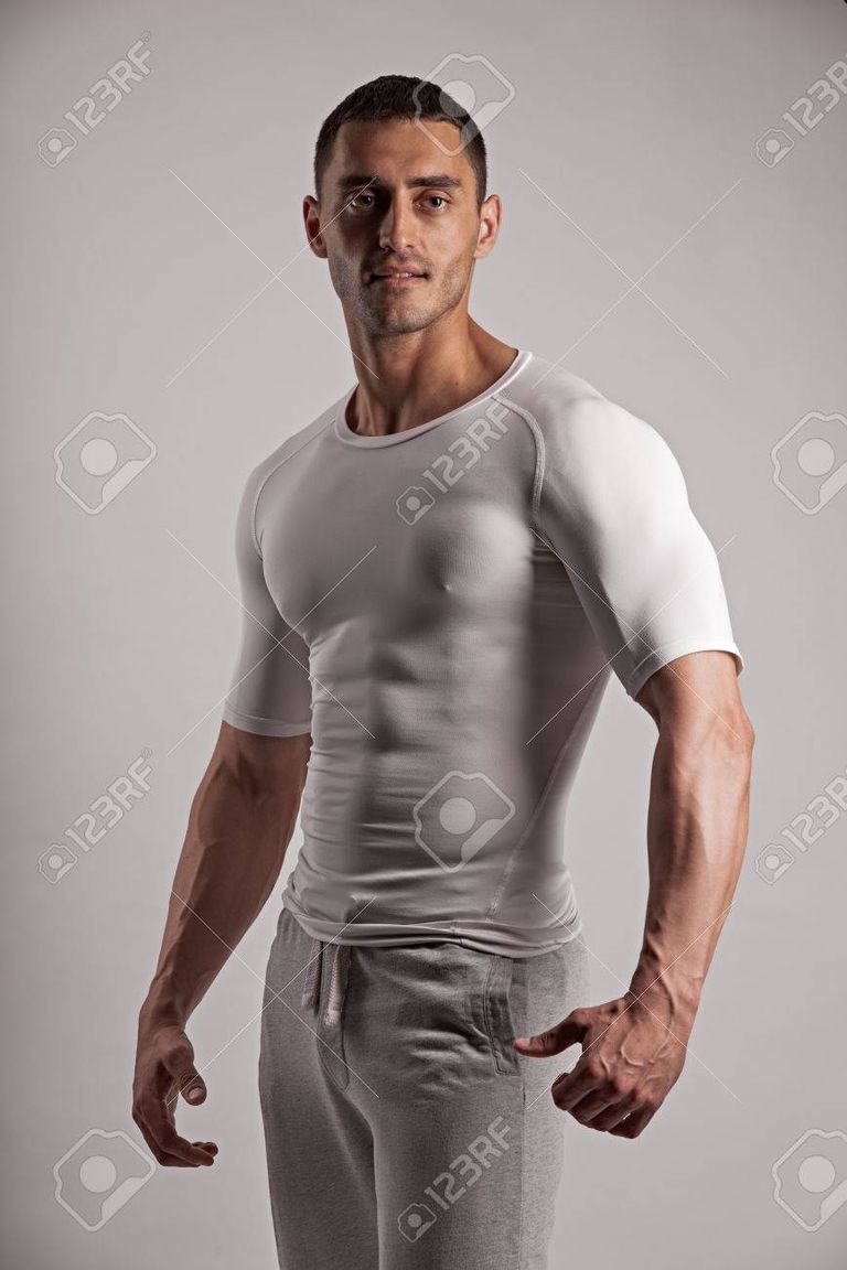 59938328-portrait-of-a-gorgeous-male-model-in-tight-clothes-standing-on-grey-background.jpg