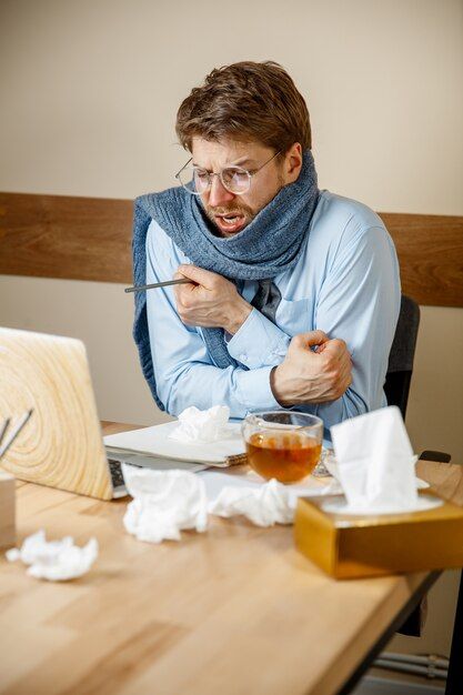 feeling-sick-tired-man-with-cup-hot-tea-working-office-businessman-caught-cold-seasonal-flu-pandemic-influenza-disease-prevention-air-conditioning-office-cause-sickness_155003-31290.jpg