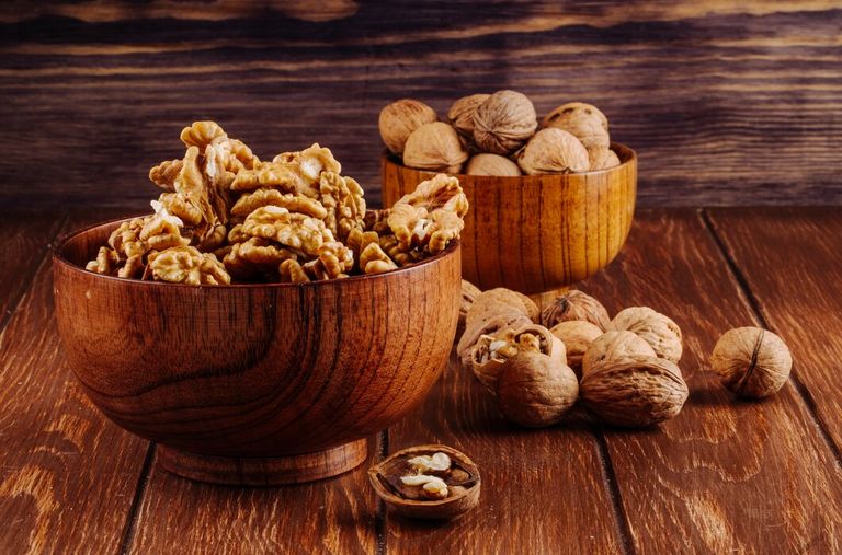 side-view-walnuts-wooden-bowl-dark-rustic-background_141793-7278.jpg