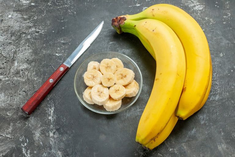 close-up-view-nutrition-source-fresh-bananas-bundle-chopped-glass-pot-gray-background_140725-139526.jpg