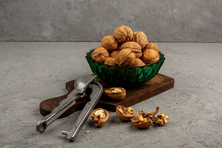 walnuts-peeled-whole-inside-green-plate-grey-desk_179666-350 (1).jpg