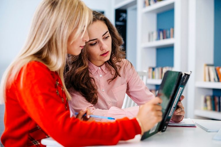 young-women-reading-textbook-together_23-2147844621.jpg