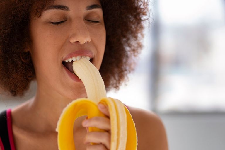 front-view-woman-eating-banana_23-2150241150.jpg