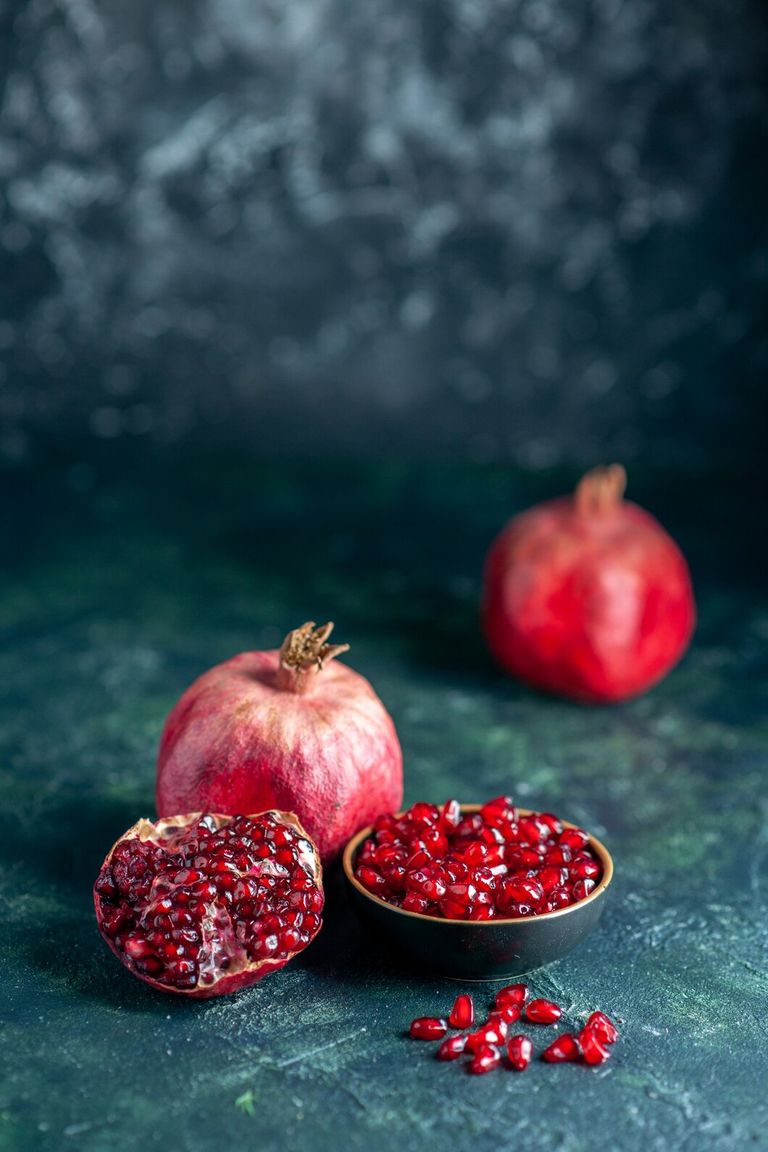 front-view-pomegranate-seeds-bowl-pomegranates-dark-surface_179666-44119.jpg