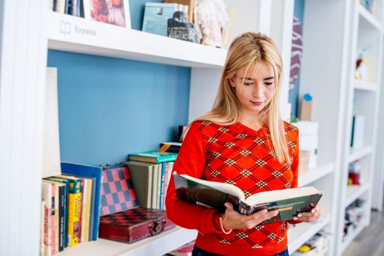 young-woman-reading-book-library_23-2147844626.jpg